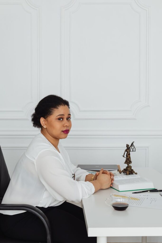 A confident businesswoman sits at her desk, embodying success and determination.