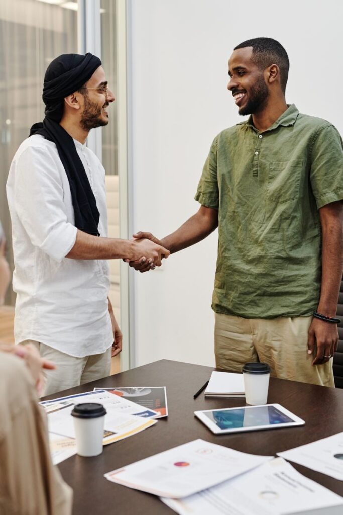Two professionals shaking hands in a friendly business meeting indoors.
