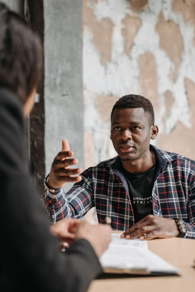 Business interaction between two adults discussing documents in a modern office.